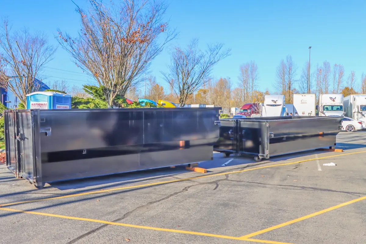 Professional dumpster rental service with roll-off container on residential driveway in Hilo